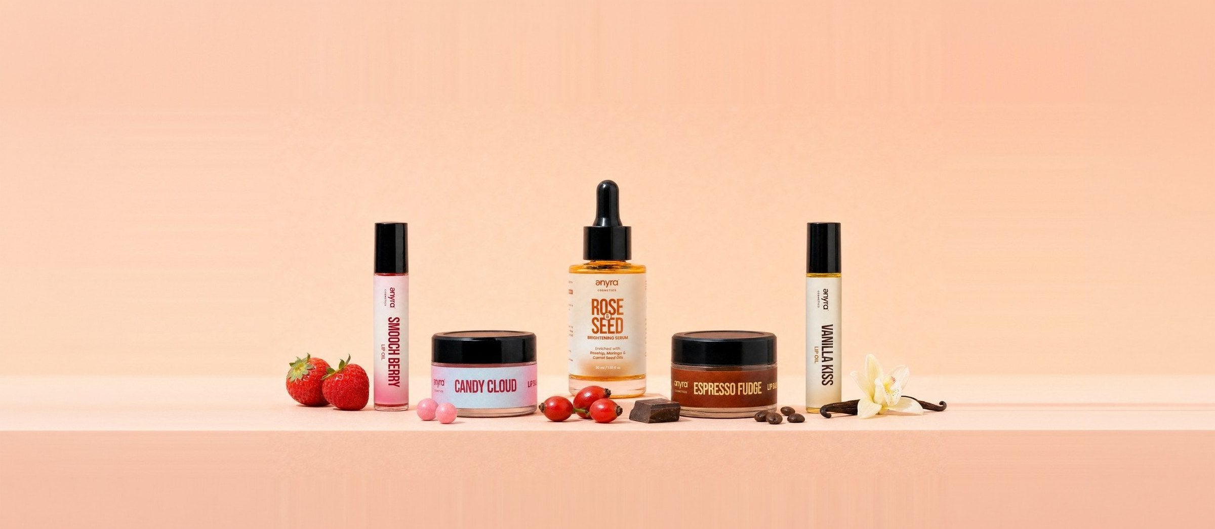 Smooch Berry and Vanilla Kiss lip oils, Candy Cloud and Espresso Fudge lip balms and the Rose & Seed Brightening Serum